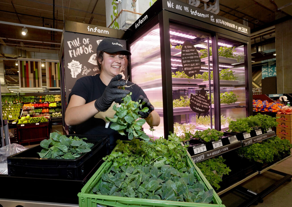 Woman with produce from Infarm, a vertical farming company, in a store.