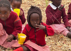 Group of young girls eating food from the school feeding program.